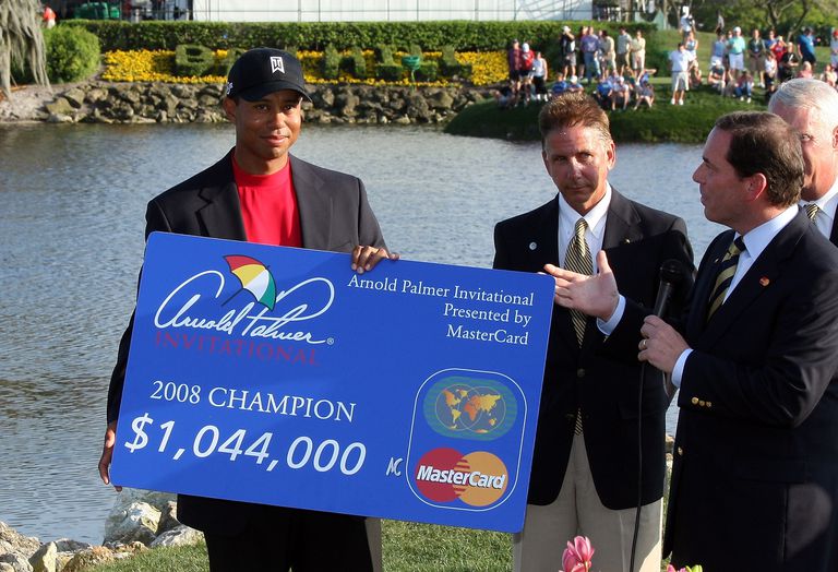 Tiger Woods with one of many checks